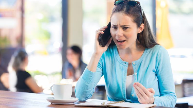 A woman looks insistent as she talks on the phone.