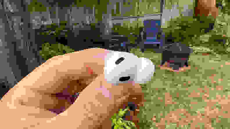 A close-up image of a hand holding a pair of Apple AirPods Pro (second gen).
