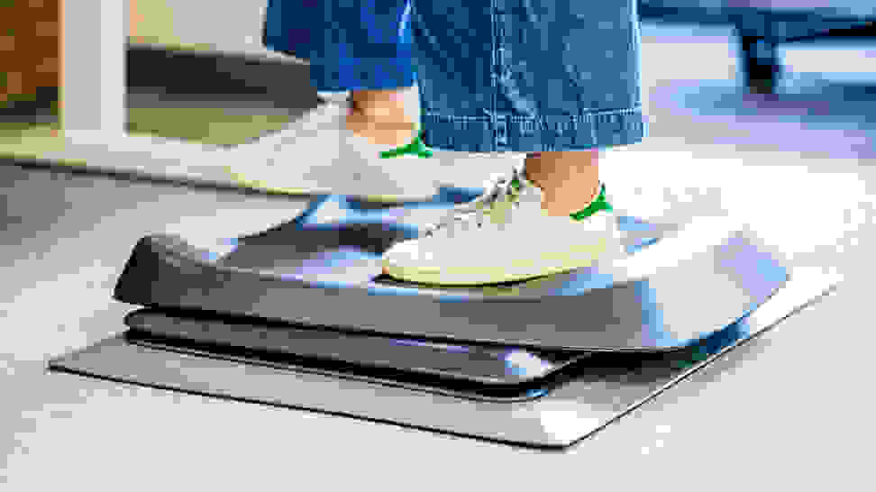 A person standing on top of standing desk mats.