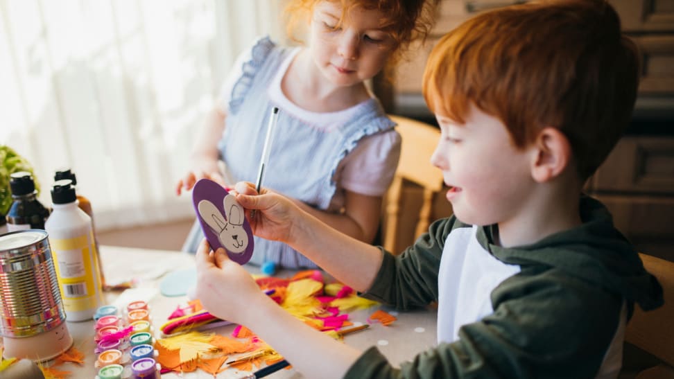 Two kids making Easter crafts at home