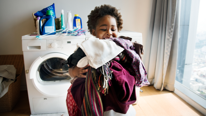 Child carrying laundry to fold