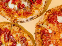 An overhead photo of three wood-fired pizzas, one cheese, one pepperoni, and one sausage and peppers.