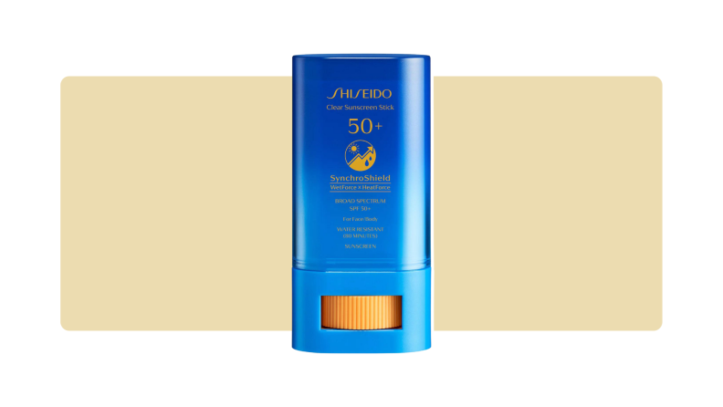 Shiseido sunscreen stick in front of a yellow background.