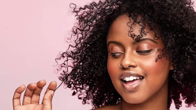 A woman enjoying the results of her hair after using a hair mask.