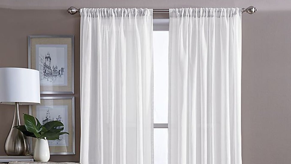 White curtains in front of window in room.