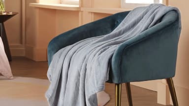 A throw blanket placed on a chair.