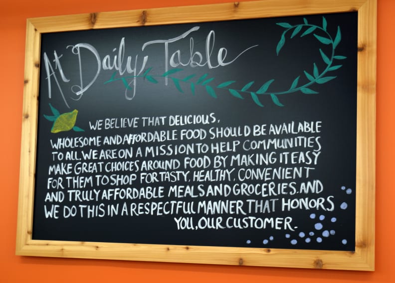 Daily Table's mission statement is proudly displayed on an artfully designed chalkboard sign.