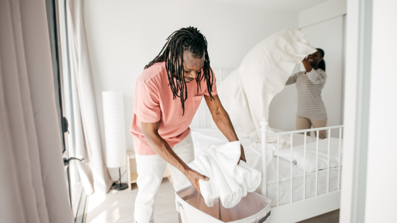 Man and woman folding sheets and linens