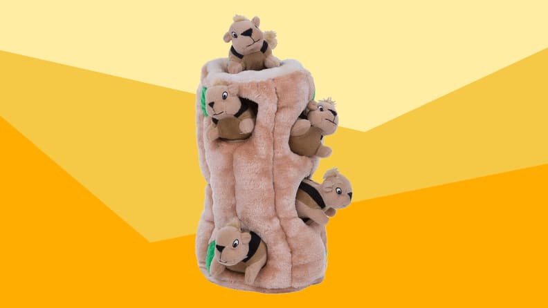 A plush dog toy against a varied yellow background.