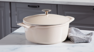 A beige Dutch oven sits on a kitchen counter.