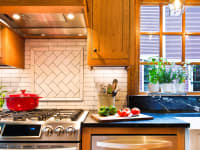 Modern kitchen with wooden cabinets and white tile backsplash.