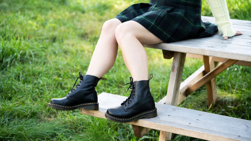 Girl sitting on a picnic table wearing Doc Martens boots.
