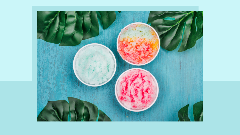 Three cups of shave ice surrounded by leaves.