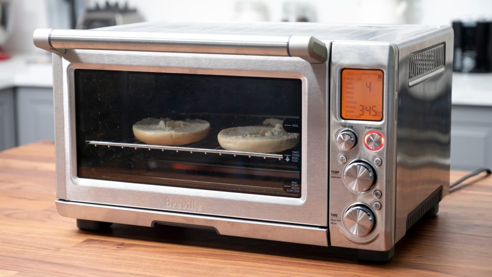 A Breville Smart Oven Pro on a kitchen counter with a bagel toasting inside.