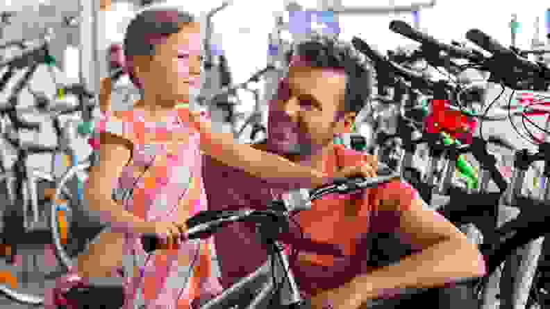 A girl proudly tests a new bike in a bike shop
