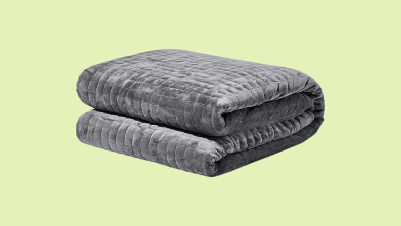 Folded weighted blanket against green background