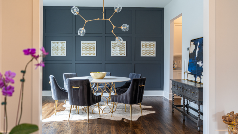 a geometric light fixture hangs over a dining room table