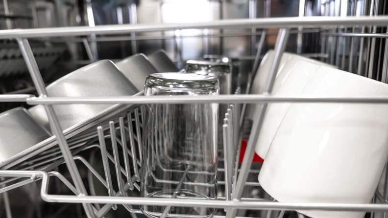 Close-up of the top rack of the Hisense HUI6220XCUS dishwasher, loaded with mugs and other dishes.