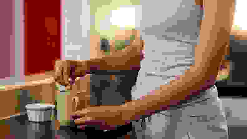 a woman stirs a mug with tea on the counter