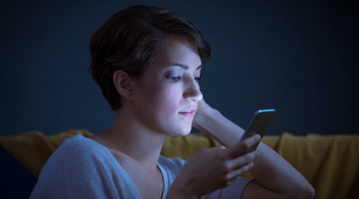 Woman in dark with mobile phone