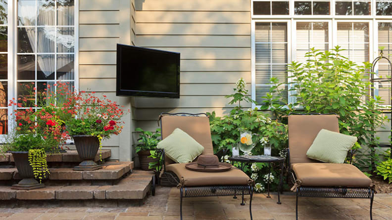 A pair of lounge chairs on a stone patio.