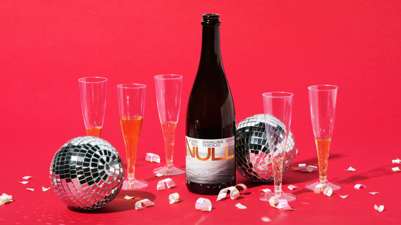 A bottle of Studio Null Sparkling Wine on a red background with confetti and disco balls.