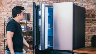 A person opens a door to a stainless steel refrigerator