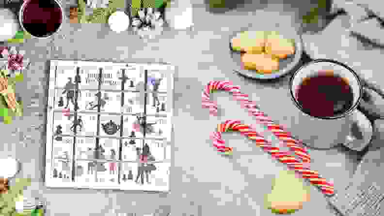 On left, the tea advent calendar shot from above. On right,  cup of tea surrounded by holiday cookies and candy canes.