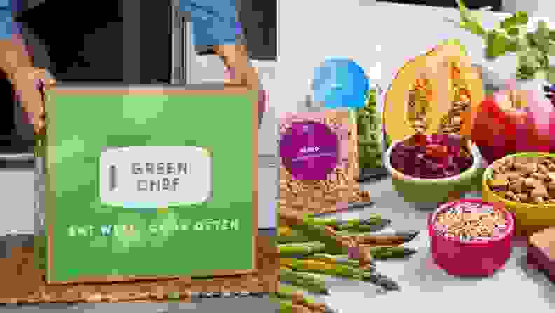 在左边,一个人举起一盒绿色厨师餐包和右边,有些成分展出,包括芦笋,farro、豌豆、南瓜、小红莓干,等等。