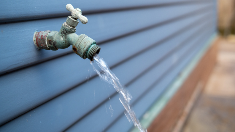 Water streaming out of outdoor faucet