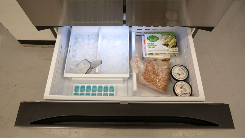 A view from above the freezer, with its internal drawer pulled out to showcase the large ice reservoir alongside additional storage.