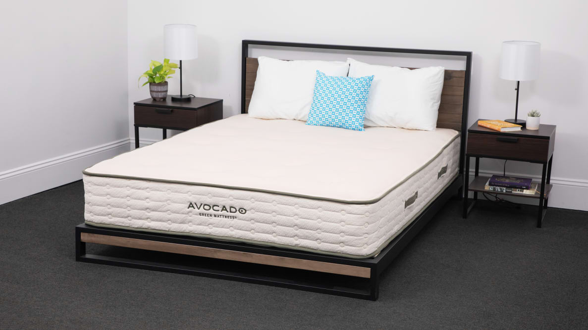 Bare avocado green mattress on a bed frame between two nightstands