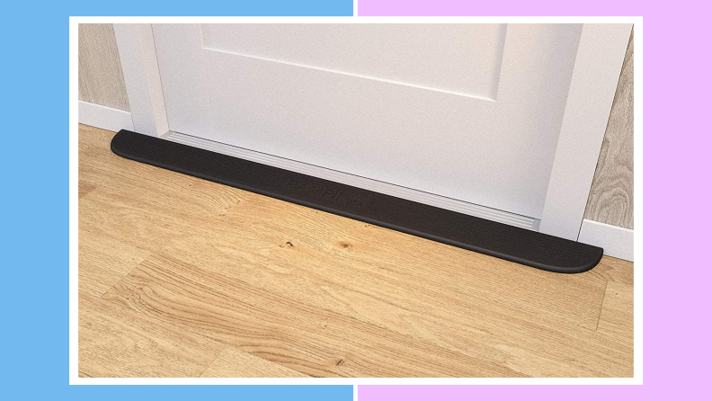 Rampit Empower Series Rubber Threshold Ramp in threshold before doorway on wooden floor in front of door.