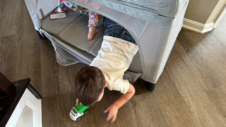 Two small toddlers playing inside of the Uppababy Remi playard.