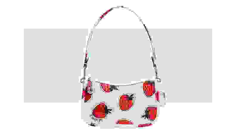 A white leather purse that features a strawberry print.