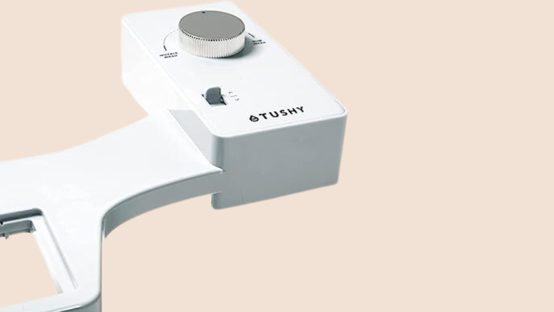 Angled front/overhead view of a tushy bidet attachment in white.