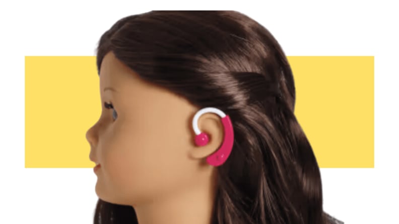 An American Girl doll wearing a hearing aid.
