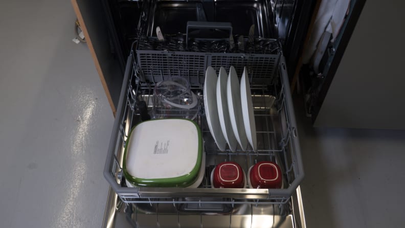 A close-up of the bottom rack, with the cutlery basket placed along its back edge.