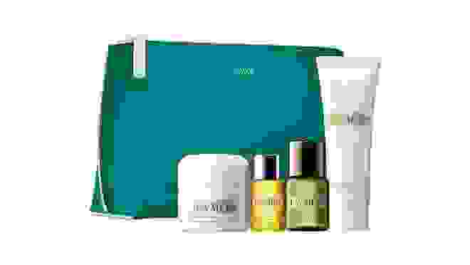 Turquoise makeup bag next to various La Mer products