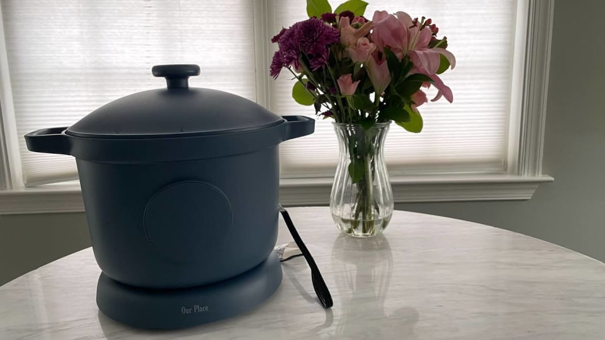 Our Place Dream Cooker in Blue Salt color on countertop surface next to vase of flowers.
