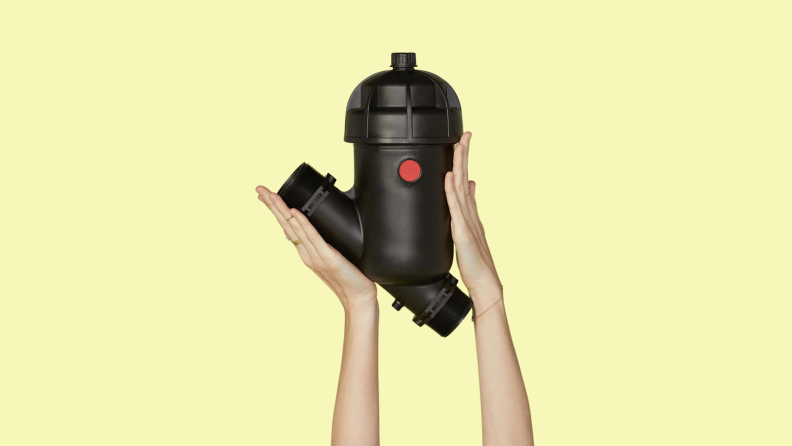 Two hands hold the Girlfriend Collective Microfiber Filter with its diagonal base and its red and black color notes.