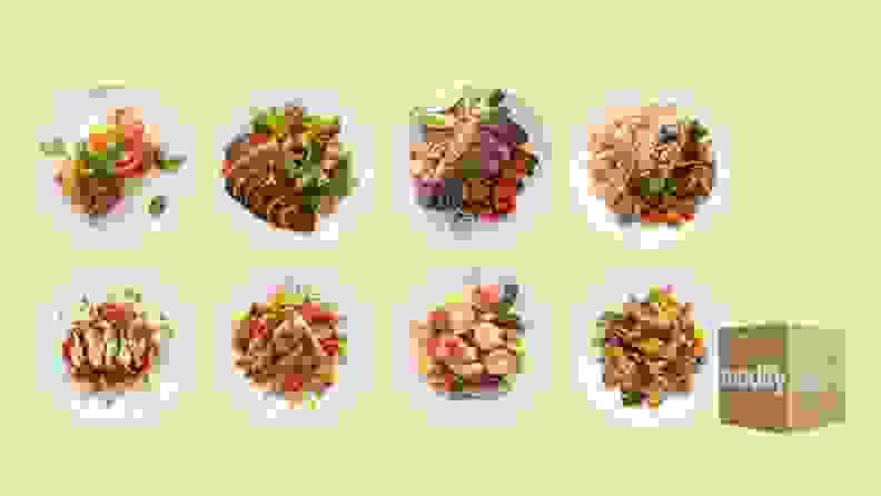 Several dishes of Modify Health meals on green background