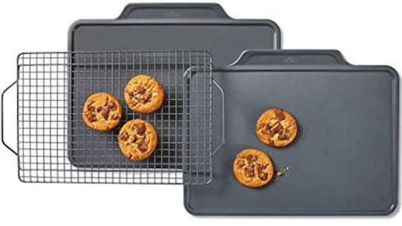 Five cookies sitting on two baking sheets and a baking rack
