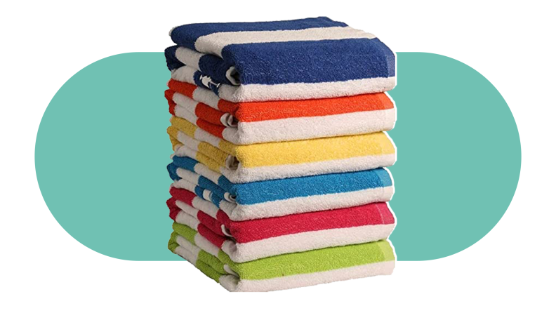 A stack of striped beach towels on a teal background.
