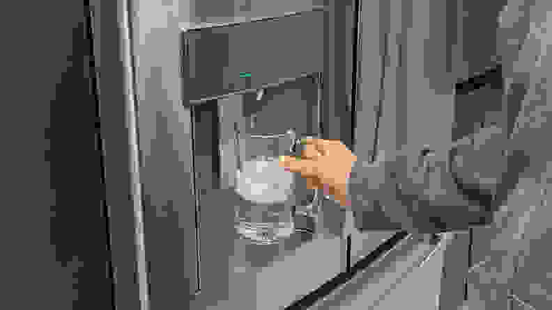 A close-up of the through-the-door dispenser. Our Lab Manager, Jonathan Chan is holding up a glass to its paddle, dispensing some ice.