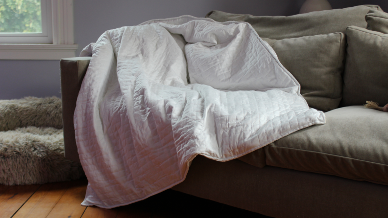 white blanket spread out on side of couch