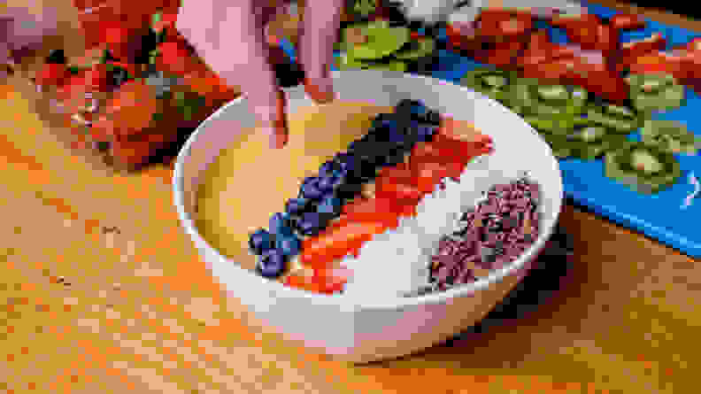 Adding blueberries to smoothie bowl