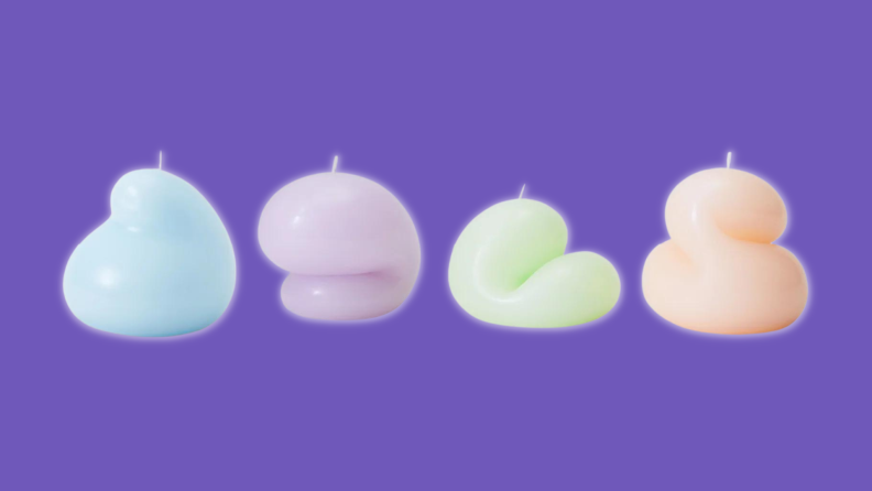 Four goober candles against a purple background.
