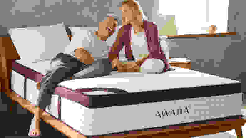 Two people laying on a Awara Premier mattress in a bedroom setup.