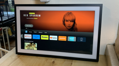 Product shot of the Echo Show 15 with Fire TV on display inside of home on wooden surface.